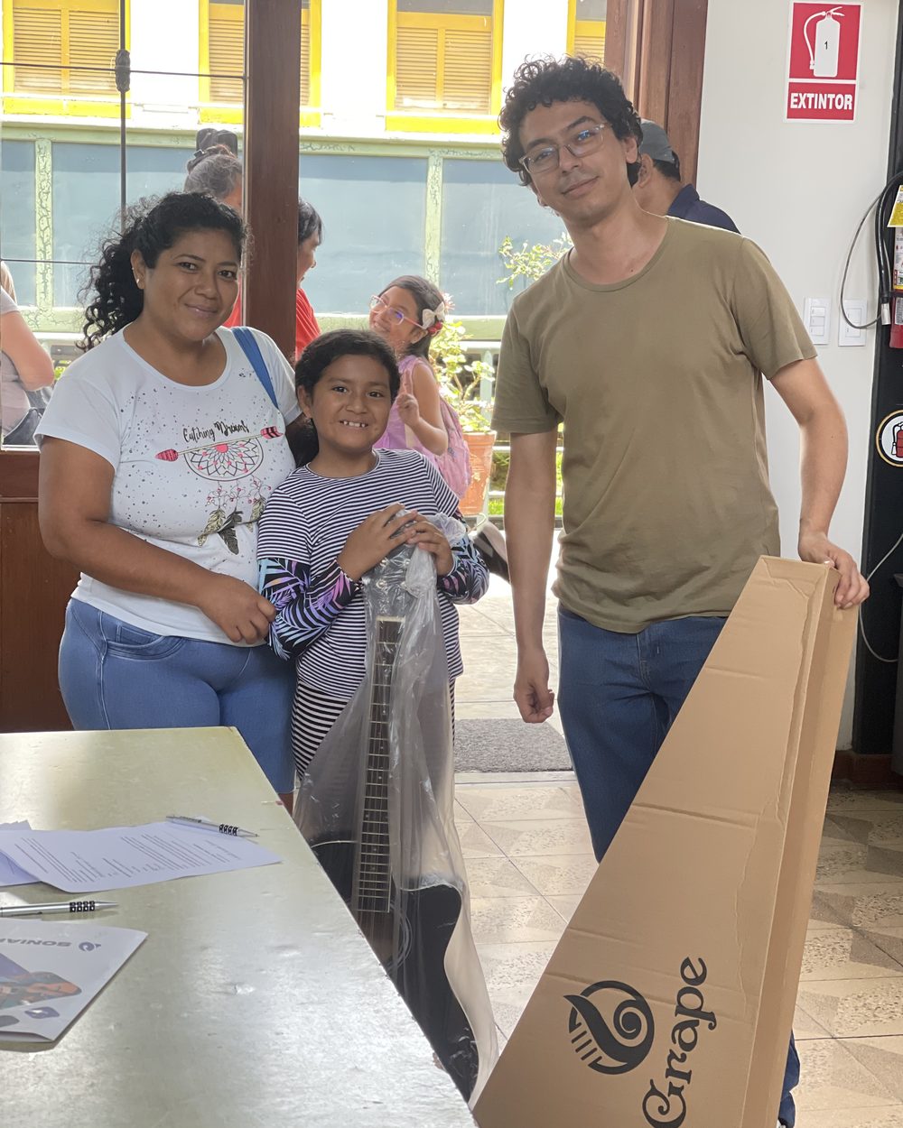 Una familia recibe la guitarra de su hijo el día de la entrega