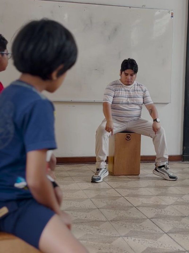 Un alumno frente al maestro de cajón en el taller de percusión